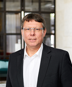 Portrait des Leiters Innovationsteam 1 Prof. Dr. Görge Deerberg. Im Hintergrund stehen zwei dunkle Sofas.