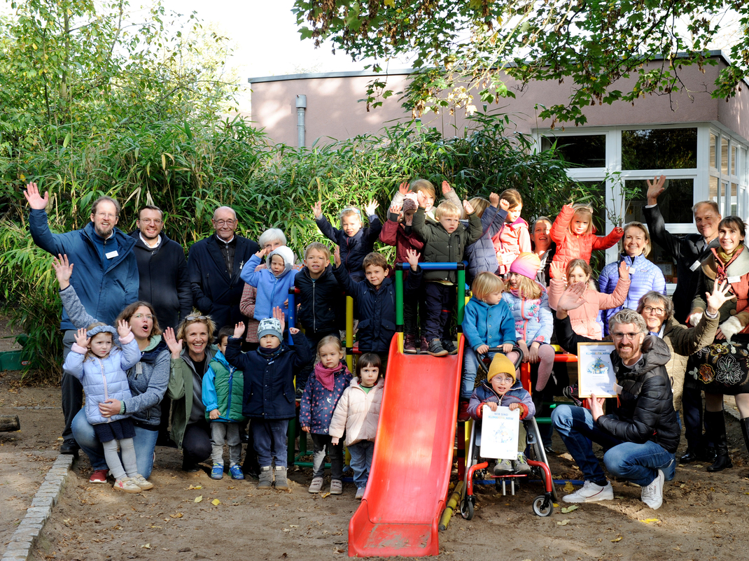 Gruppenfoto mit allen Kindern und Teilnehmenden der Auszeichnungsfeier im Garten des Kinderforum e.V.